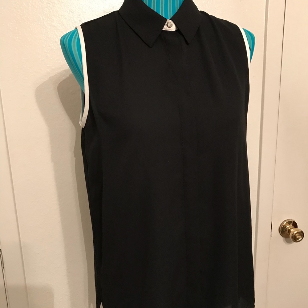 Black sleeveless blouse with much detail.